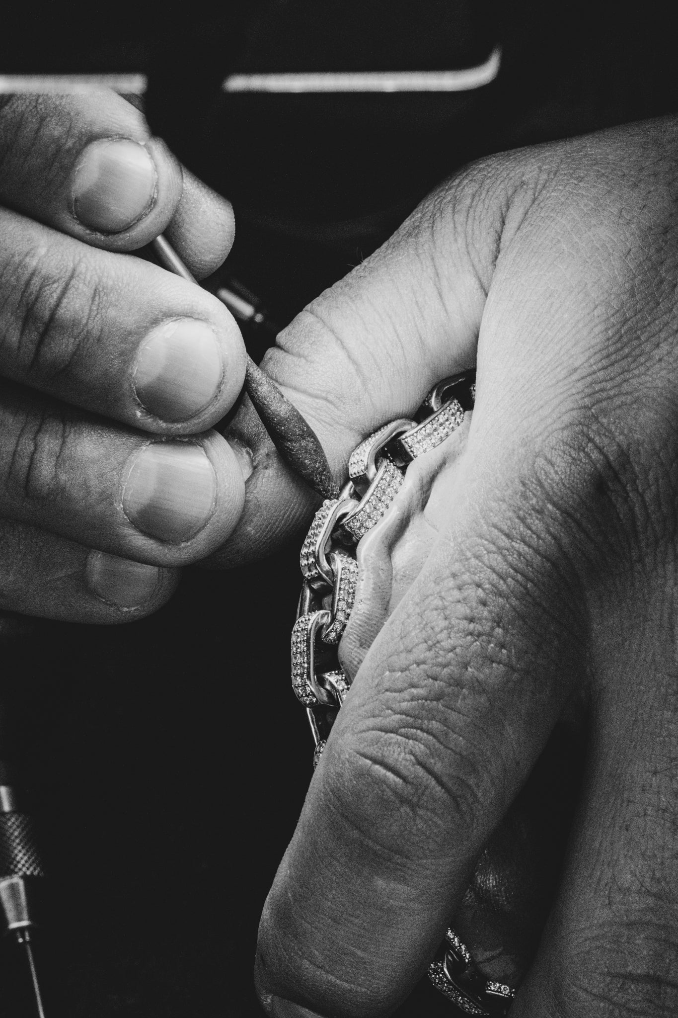 Steinsetzer fasst Diamanten präzise in ein Armband ein.